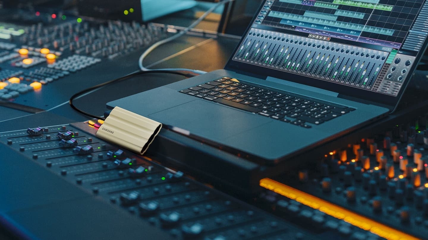 Samsung T7 Shield portable SSD connected to a laptop in an audio editing setup