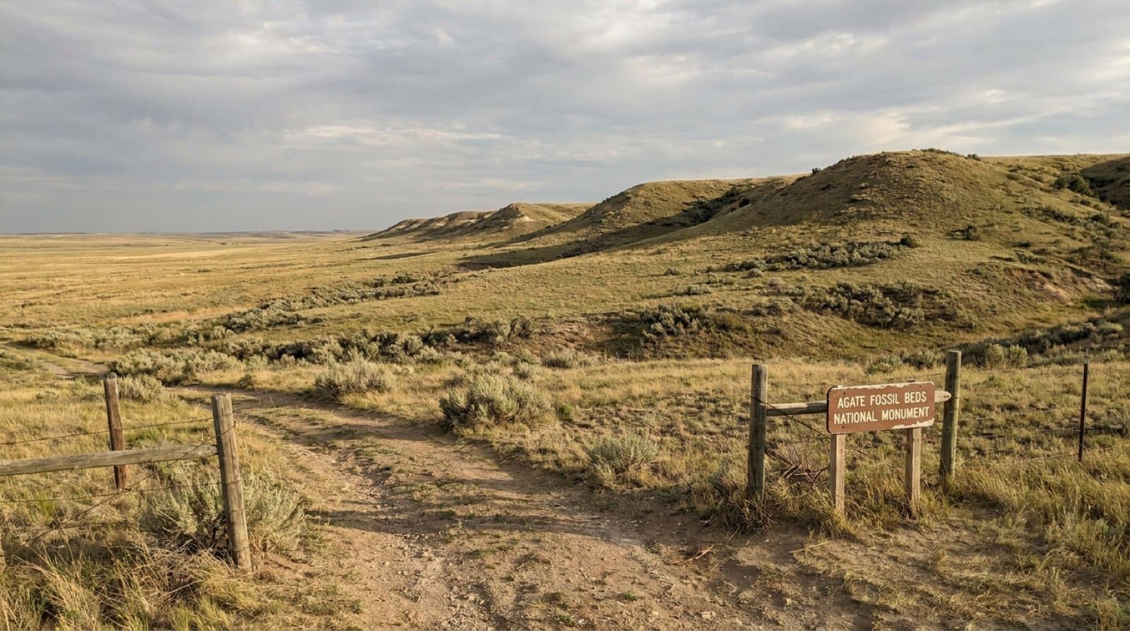 The rounded grassy fossil hills of Agate Fossil Beds rising over open Nebraska prairie under a vast sky