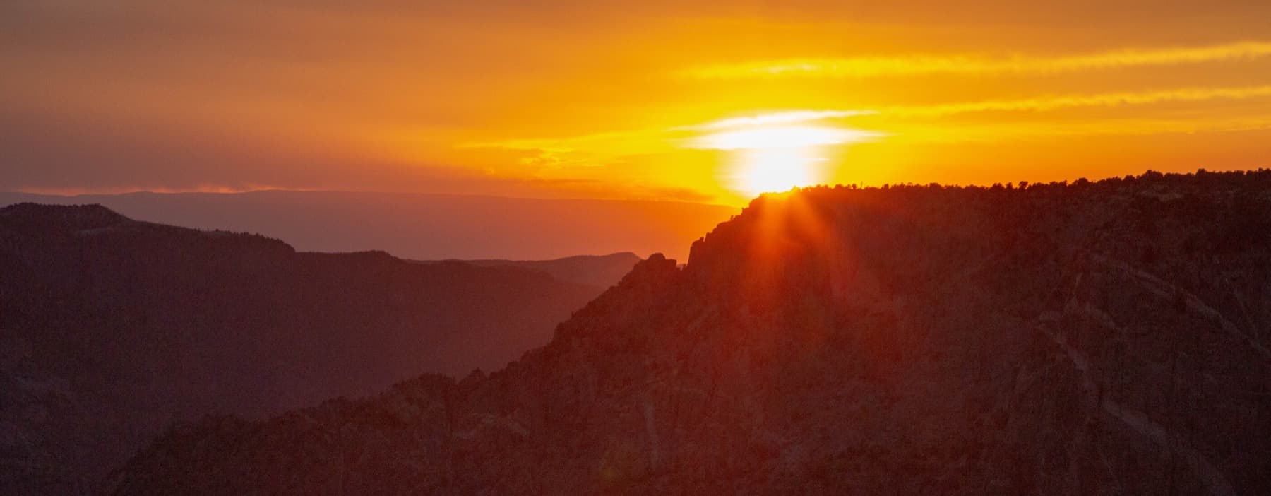 Backlit cliffs of Black Canyon at sunset