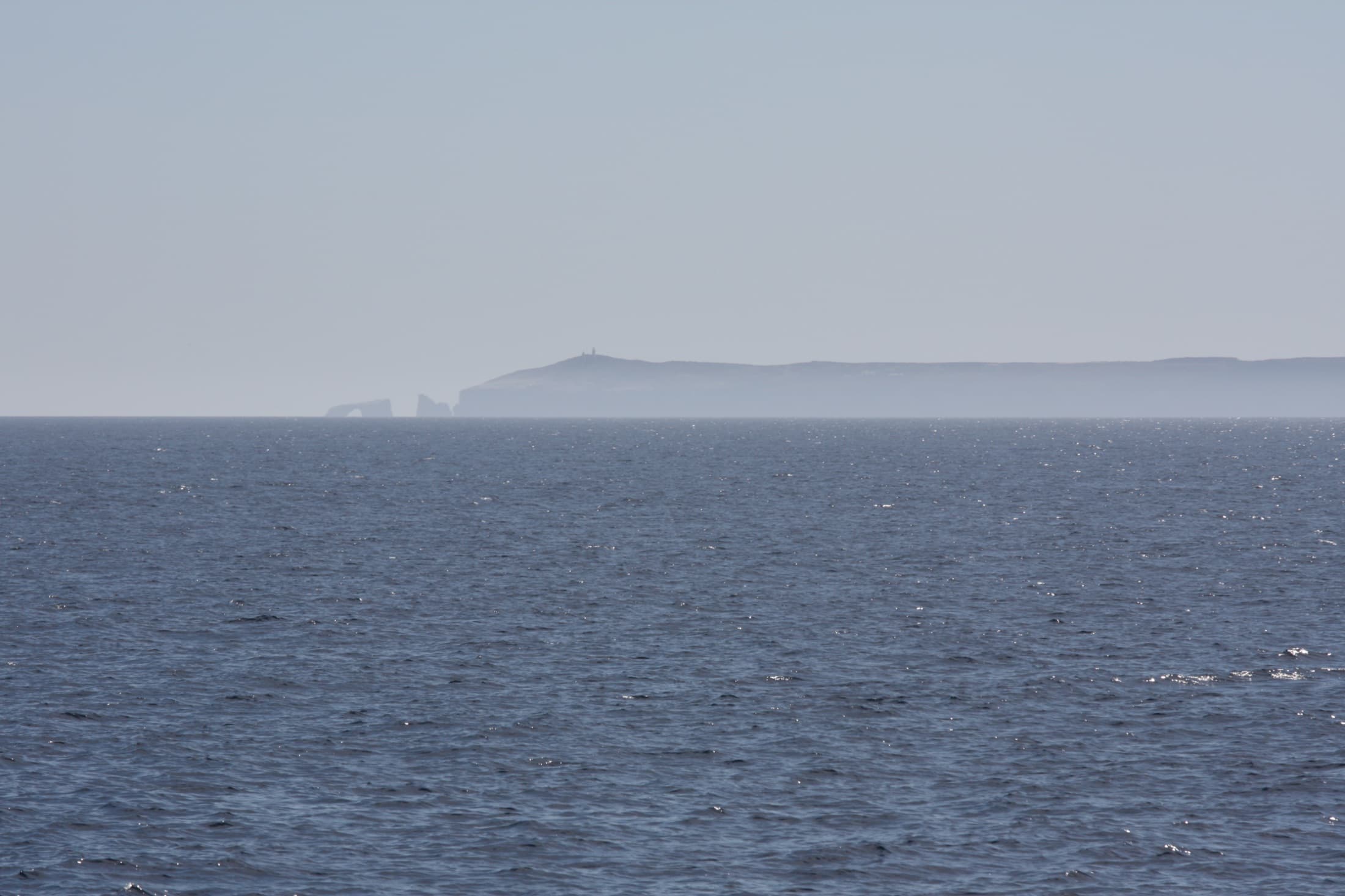 Arch Rock, the iconic 40-foot natural sea bridge at the east end of Anacapa Island in Channel Islands National Park, rising from the blue Pacific Ocean off the California coast under a clear sky