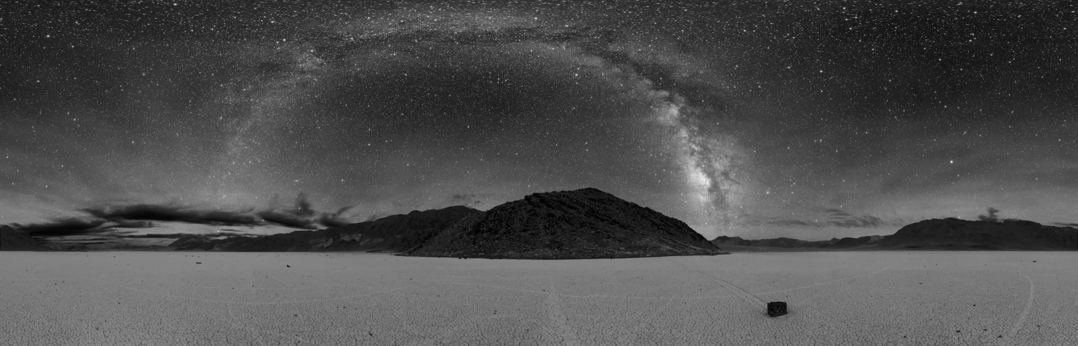 Wide panoramic landscape of Death Valley National Park at dusk, with layered desert mountain ridges receding under a deep blue twilight sky.
