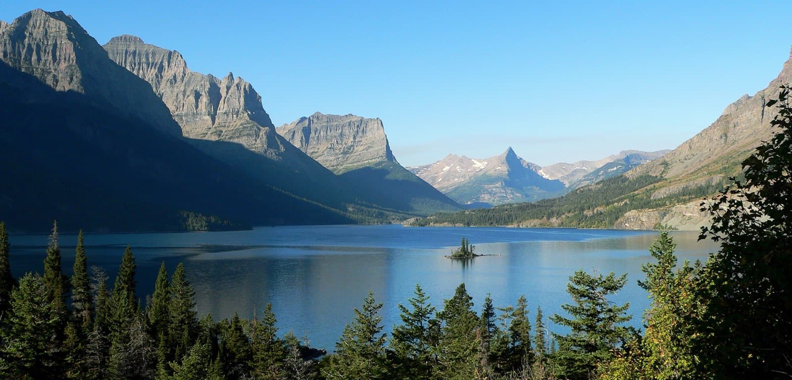 St. Mary Lake with tiny Wild Goose Island in the foreground, framed by towering peaks of Glacier National Park, Montana, seen from Going-to-the-Sun Road.