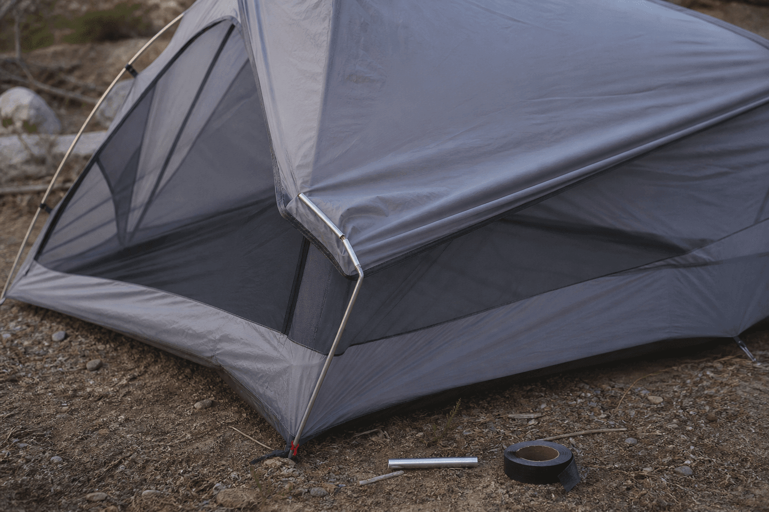 A backpacking tent sagging where an aluminum pole has kinked and split beside a joint