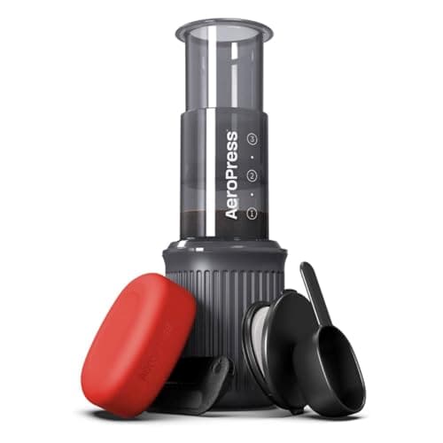 AeroPress Go on a wooden camp table by an alpine lake