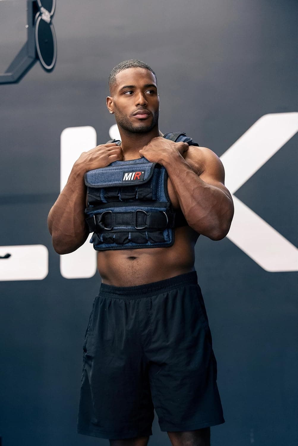 A person wearing the miR Air Flow adjustable weighted vest in a gym
