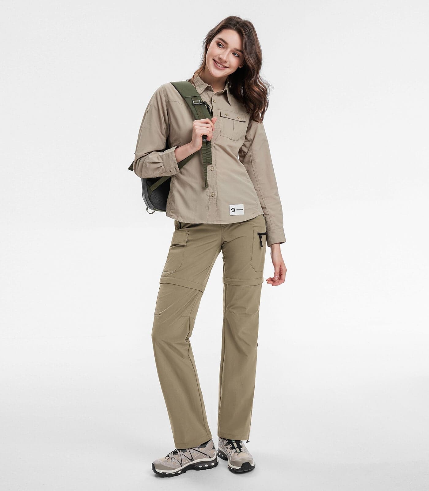 A hiker wearing lightweight full-length convertible hiking pants