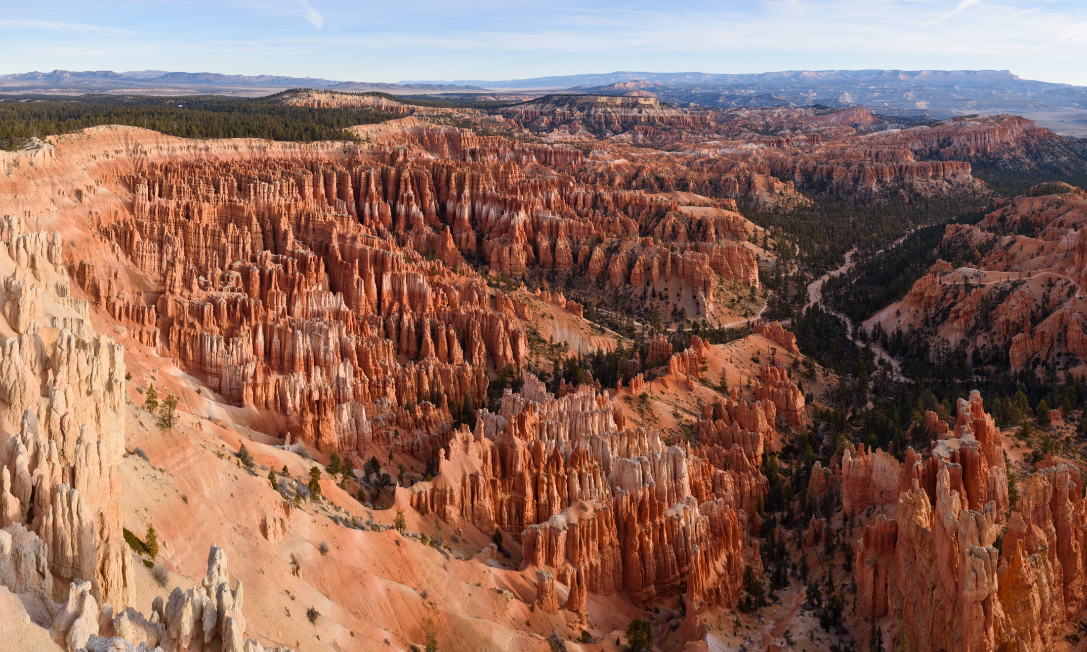 Panoramic view from Inspiration Point of the Bryce Amphitheater in Bryce Canyon National Park, with thousands of orange and white limestone hoodoos descending into the bowl-shaped canyon under a clear sky