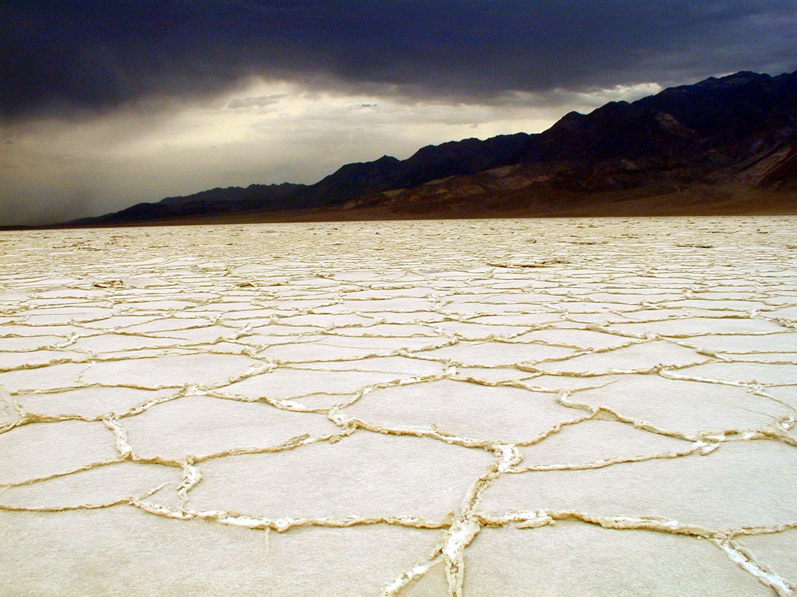 White salt flats under dark storm clouds in Death Valley