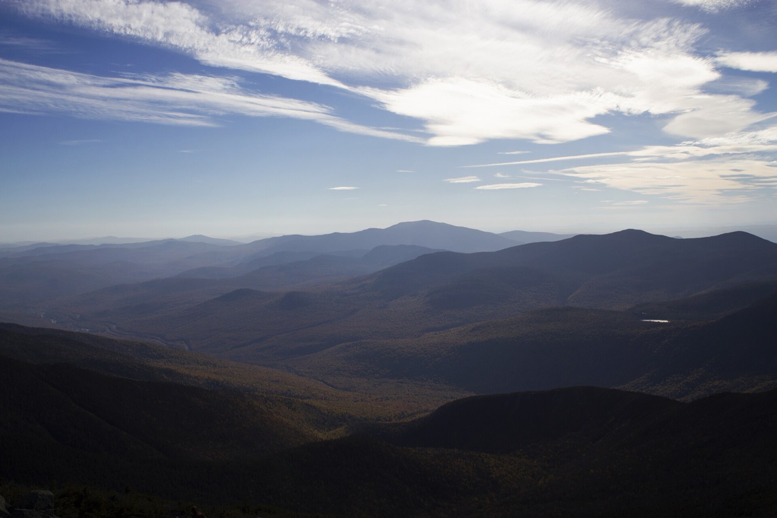 Franconia Notch in autumn from a high summit, the parkway threading the valley floor between forested ridges
