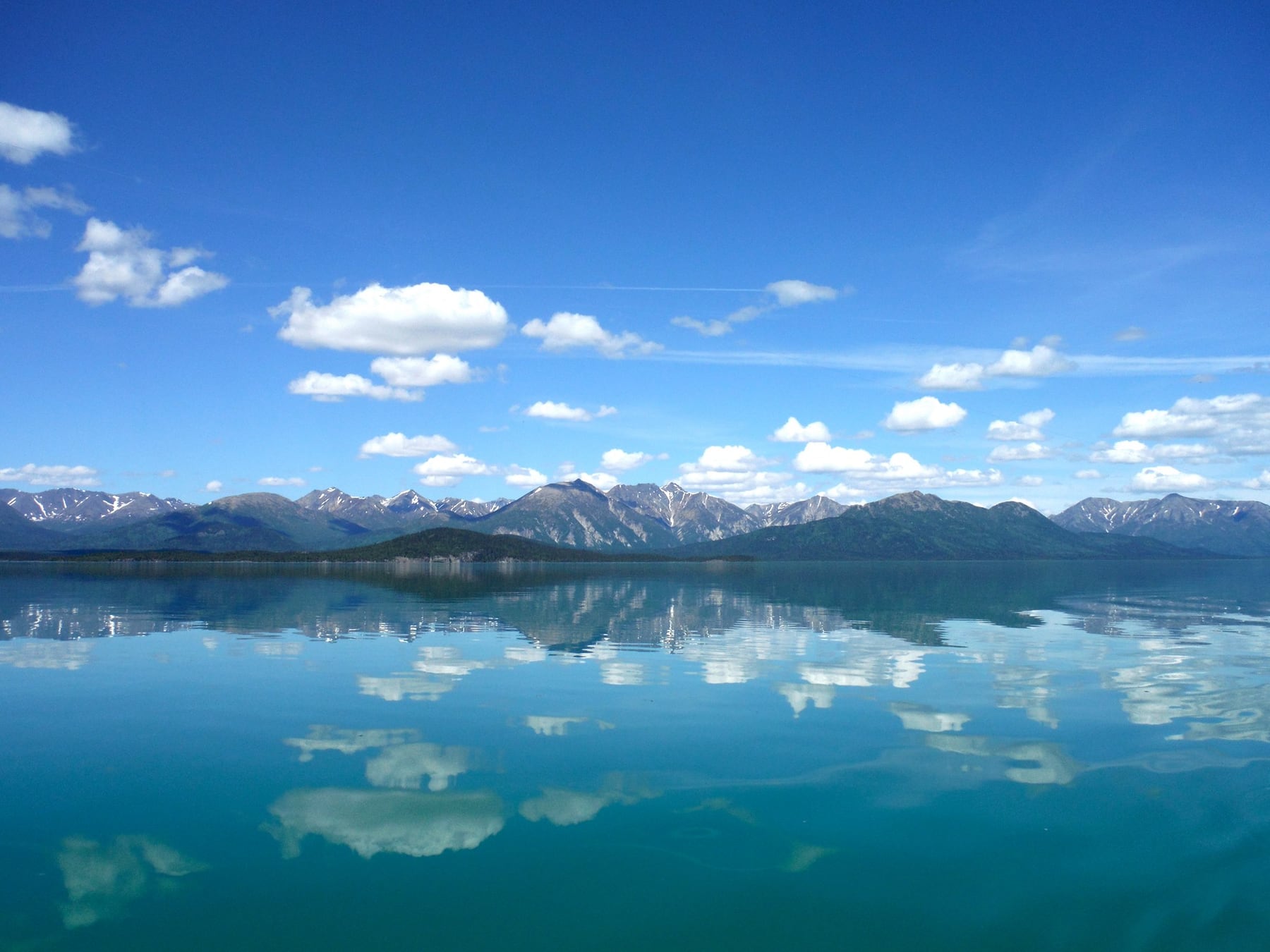 Calm Lake Clark reflecting clouds and mountains
