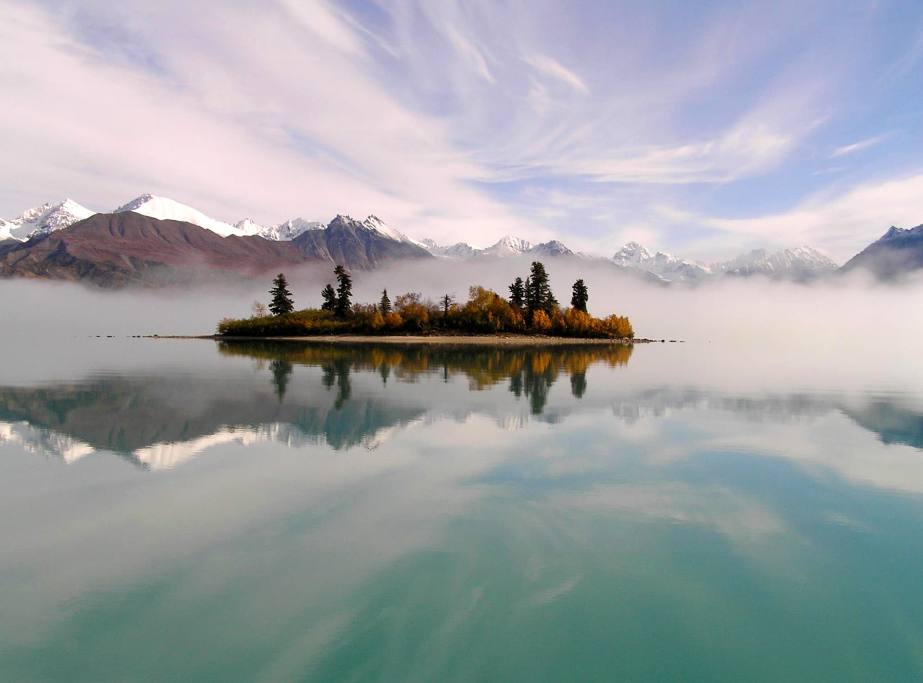 Telaquana Lake reflecting a colorful sky and mountains