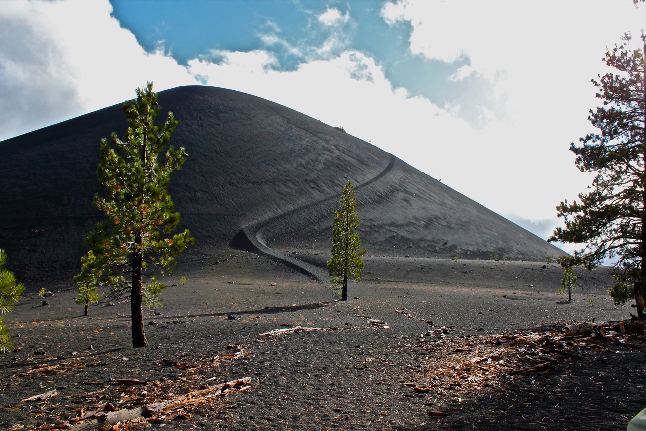 The dark volcanic slope of Cinder Cone under open sky