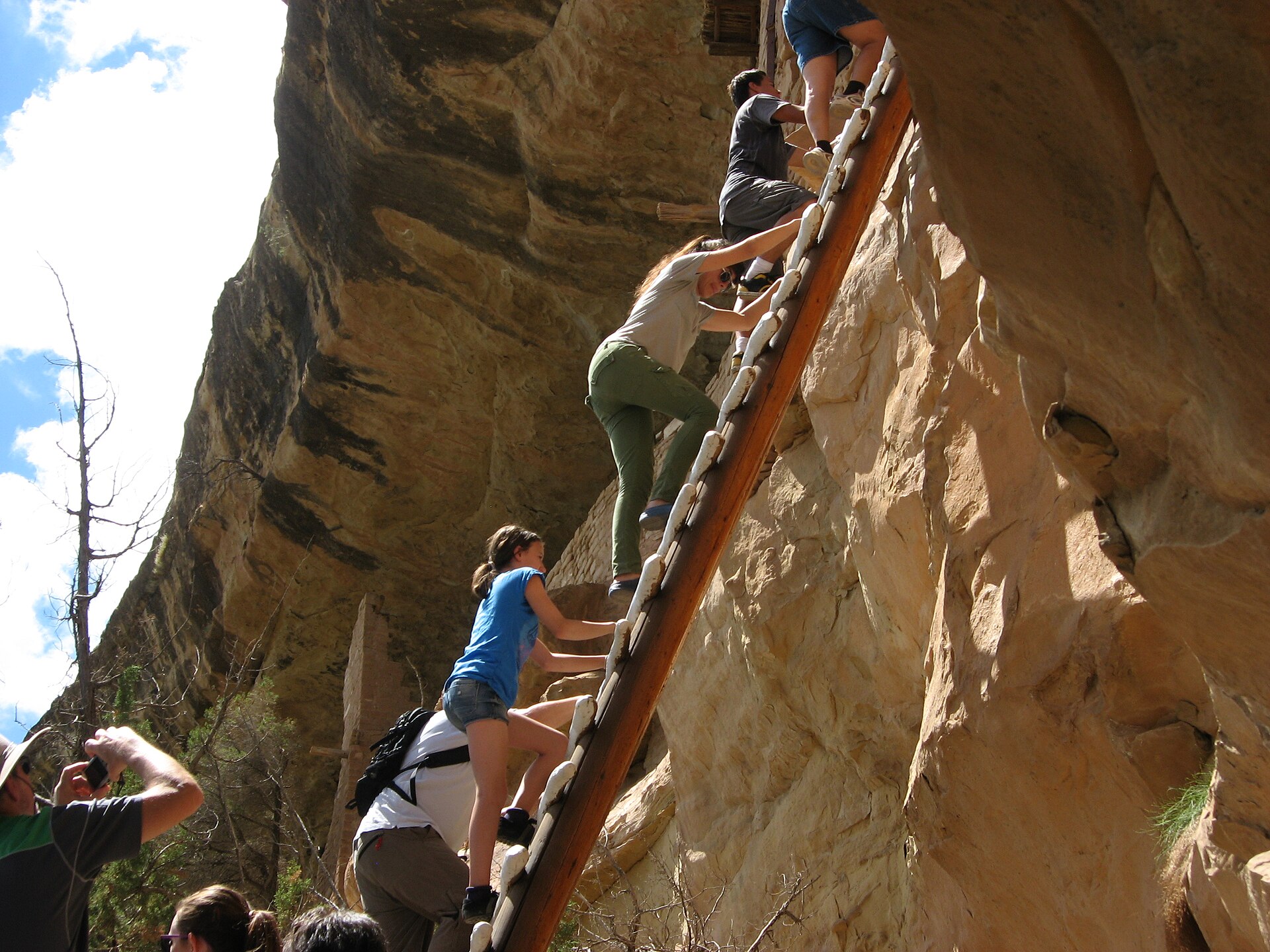 Visitors climbing the ladder route to Balcony House