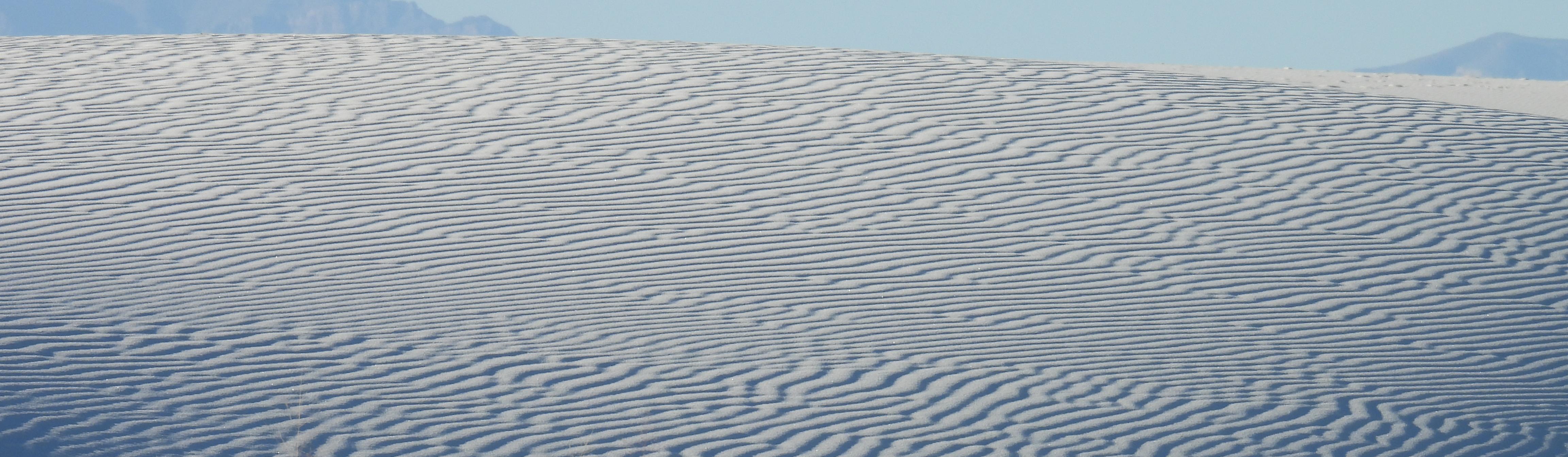 White gypsum dunes stretching toward distant New Mexico mountains