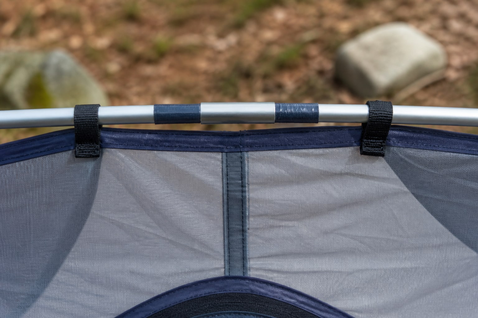 A smooth repair sleeve centered over a broken tent pole and secured with short tape wraps at both ends