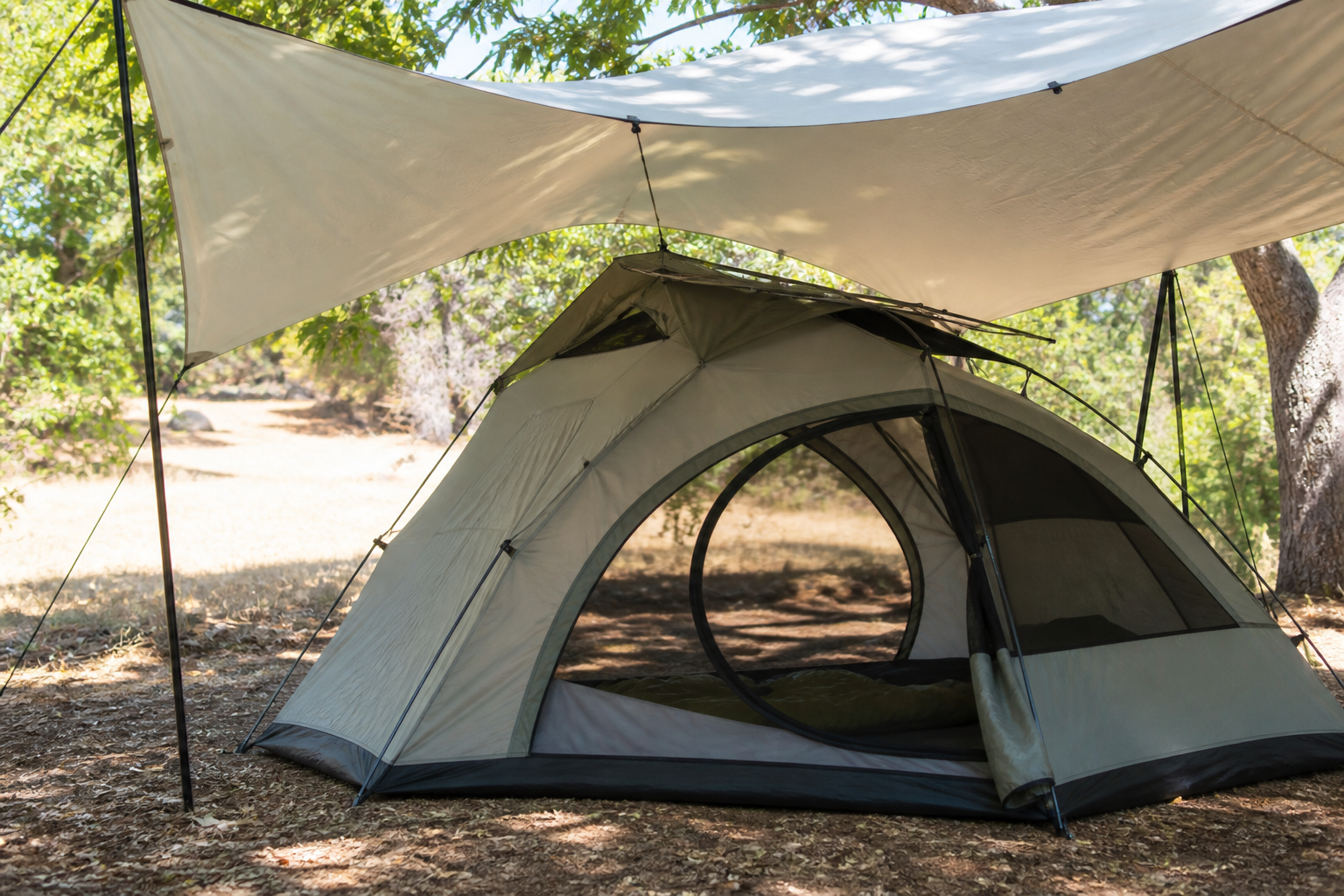A summer tent shaded by a raised tarp with its low door and high vents open for airflow